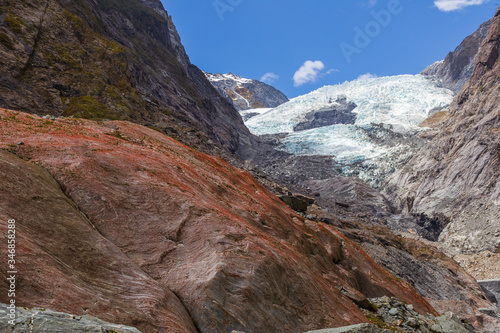 Red boulder on a background of a glacier. Franz Joseph Glacier. South Island, New Zealand