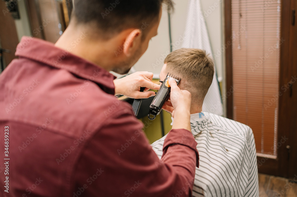 Back view of male hairdresser giving a haircut