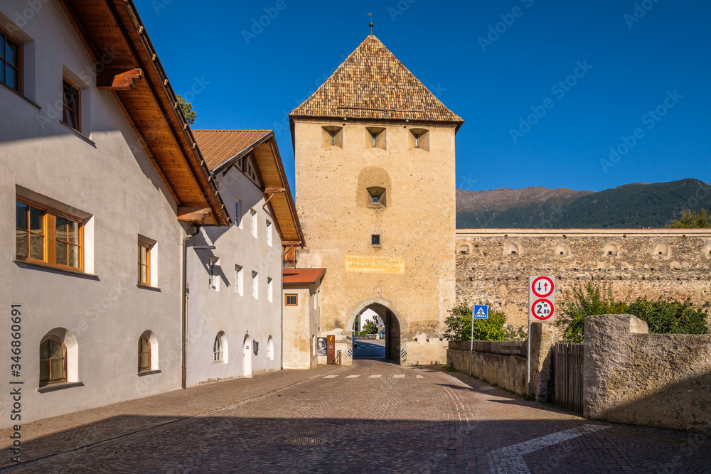 A street is leading towards one of the many tower gates in the Italian village of Glorenza, situated in the valley Val Venosta in the region of Alto Adige (Italy)