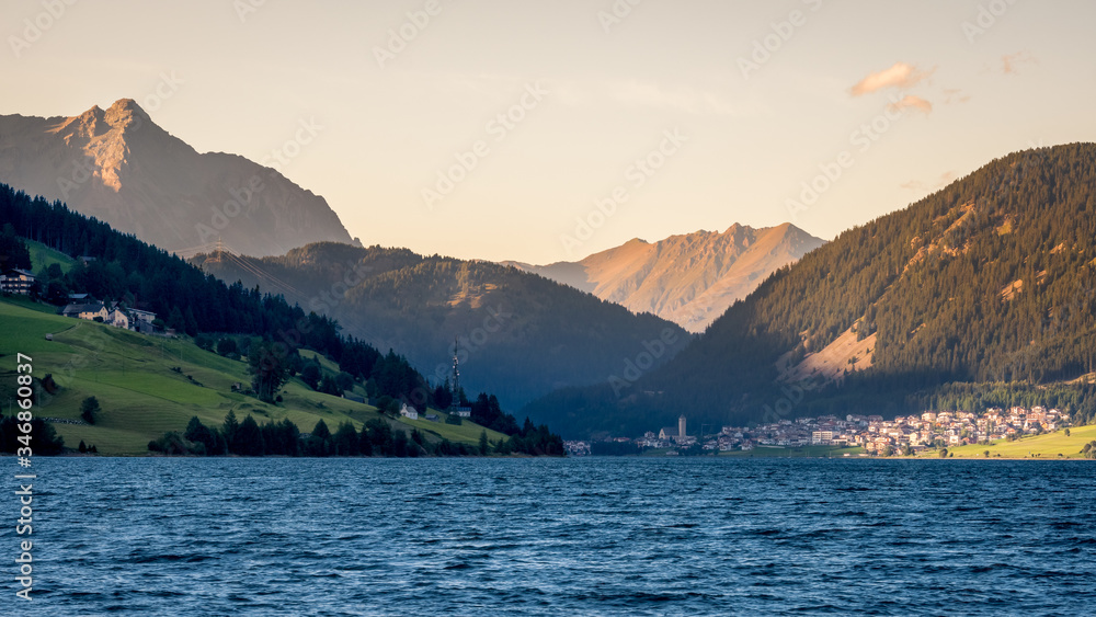 Sunset at Lake Resia (German: Reschensee) and the village of Resia in Val Venosta (Alto Adige, Italy). It lies next to Lake della Muta (German: Haidersee) and across the Austrian border at Resia Pass