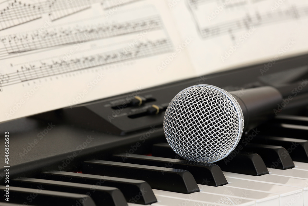 microphone on the electric piano and music paper microphone on the electric piano and music paper
