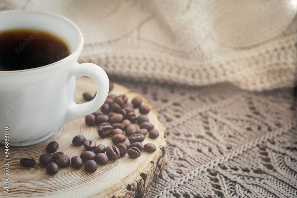White cup of black hot coffee drink and coffee beans White cup of black hot coffee drink and coffee beans