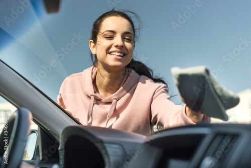 Woman cleaning the front windscreen on her car photo