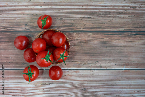 Flat Lay top View Organic Fresh Tomatoes Pile in Basket on the Left of Wooden Table with Copy Space on the Right for Your Own Text