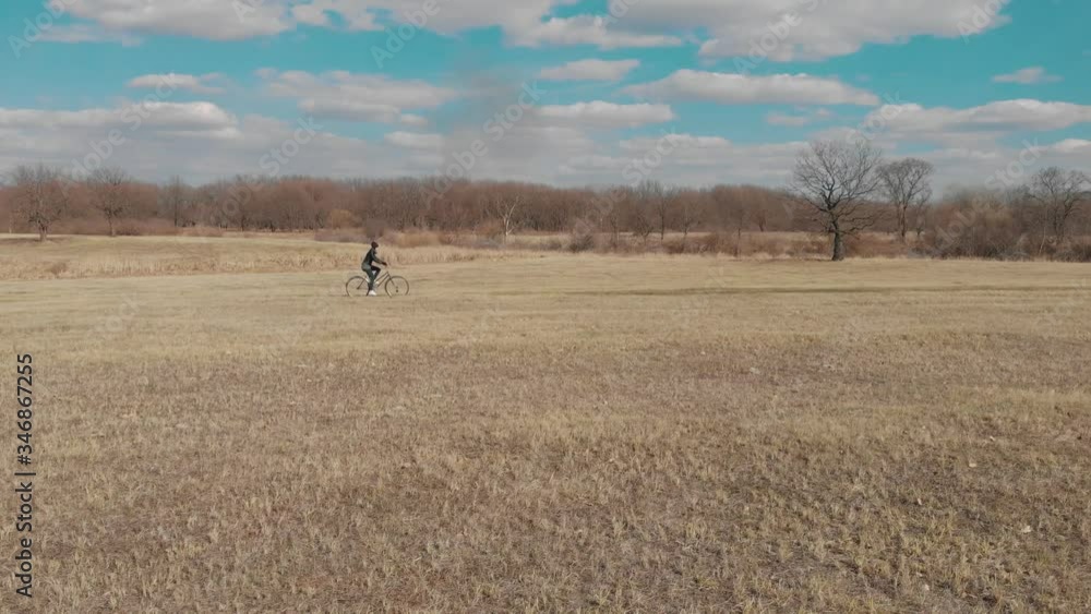 Aerial view of a cyclist riding on his bicycle on road at nature. Aerial view of a cyclist riding on his bicycle on road at nature.