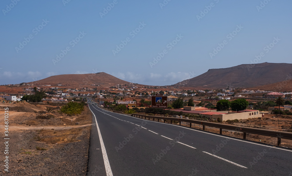The beautiful volcanic landscape in Tamariche with road on the island of Fuerteventura. Canary Islands. Spain. October 2019 The beautiful volcanic landscape in Tamariche with road on the island of Fuerteventura. Canary Islands. Spain. October 2019