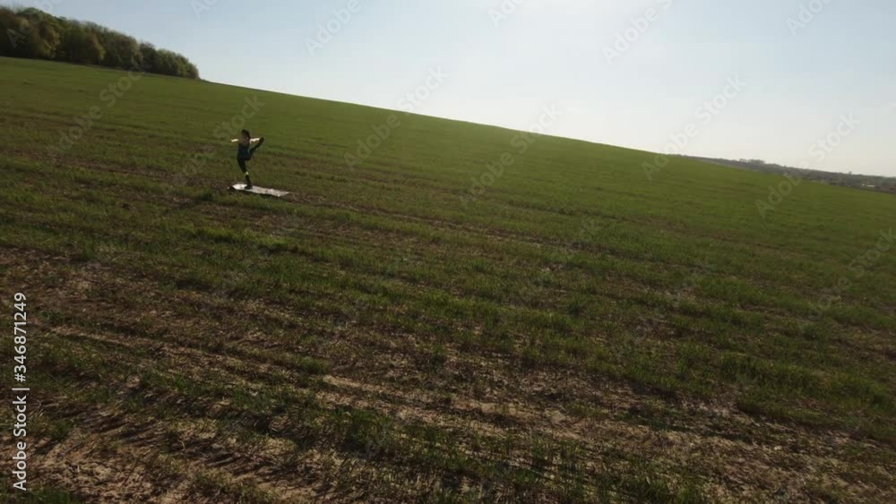 Aerial fpv drone shot of fitness woman stretching yoga exercises in nature. Creative authentic shot Aerial fpv drone shot of fitness woman stretching yoga exercises in nature. Creative authentic shot