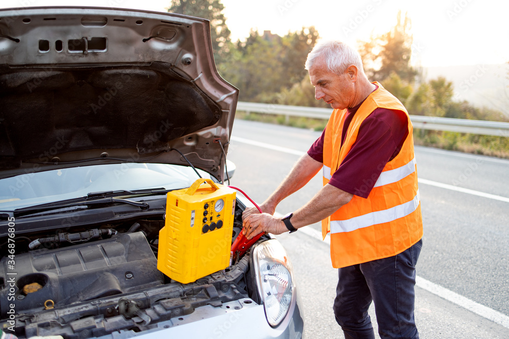 Fototapeta premium Repairer, transports a broken car on the road and fix problems on vehicle