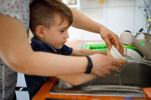 Boy Washing brushes in the sink