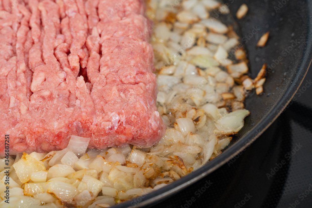 minced meat fried in onions in a black pan minced meat fried in onions in a black pan