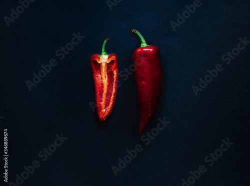 Flat lay top view of a half of red pepper over dark rustic background with vibrant colours, copy space