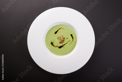 Green cream soup in white bowl