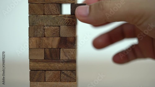 Business risks concept. Hand pulls out wooden brick with jenga game. jenga falls