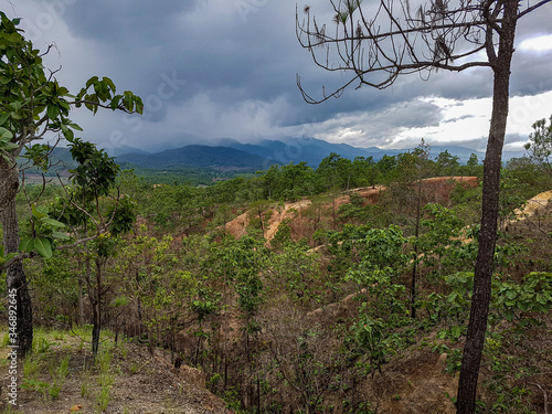 Dark weather clouds sun shine light right side rain forest trees sanstone yellow canyon pai north chiang mai mountains photo