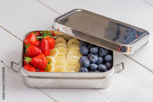 Blueberries, bananas and strawberries in plastic free container.