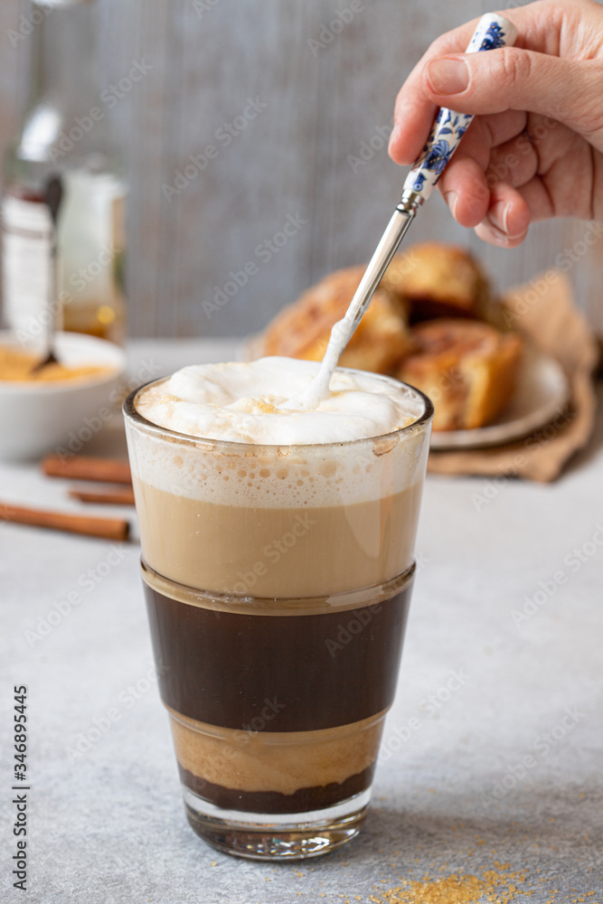 hand mixing milk foam in coffee cup, vertical hand mixing milk foam in coffee cup, vertical