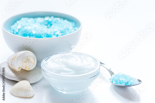 set for bath with blue salt and shells on white table background
