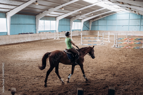 a woman riding a horse in the riding hall © Christina