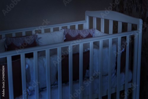 Baby bed crib with white and burgundy color pillows with laces