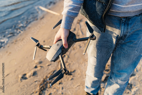 A quadcopter in the hands of a guy on the beach