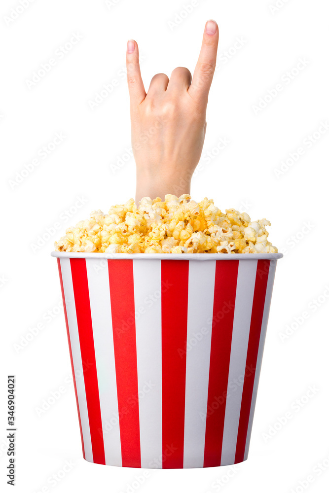 Female hand sticks out of a bucket with popcorn isolated on white background Female hand sticks out of a bucket with popcorn isolated on white background