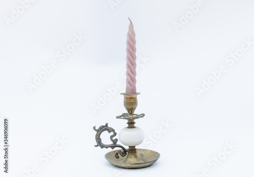 Vintage copper candlestick with pink candle - isolated on white background