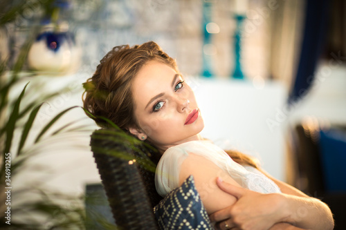 Portrait of pretty young blond bride with hairdressing sitting in the chair