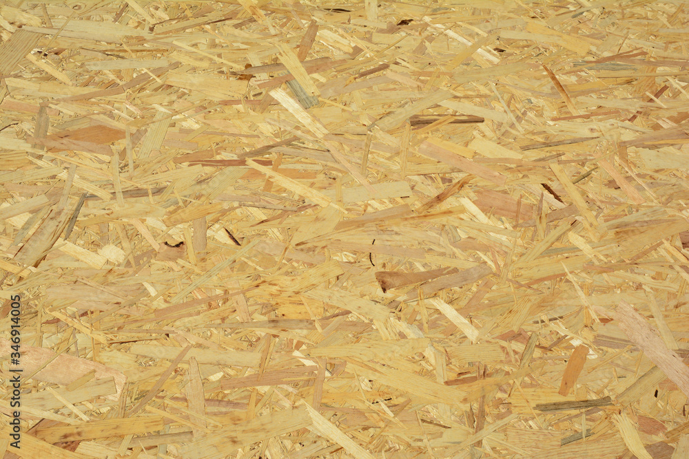 A close-up on oriented strand board, OSB wood panel, flakeboard, sterling board, plywood or sheet timber product texture background. A close-up on oriented strand board, OSB wood panel, flakeboard, sterling board, plywood or sheet timber product texture background.