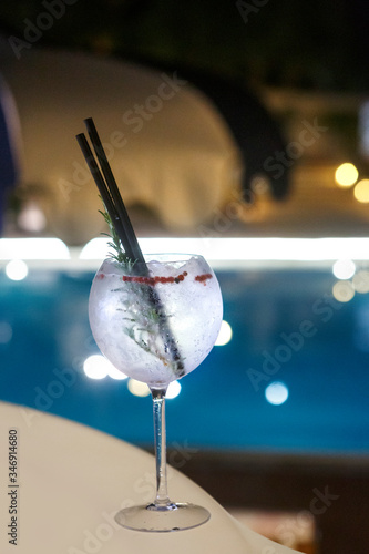 Cocktail isolato su un tavolo con sfondo piscina e locale notturno photo