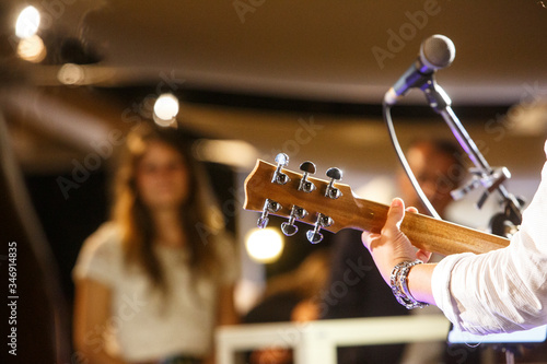 chitarra in primo piano durante un concerto e sullo sfondo il pubblico sfocato photo