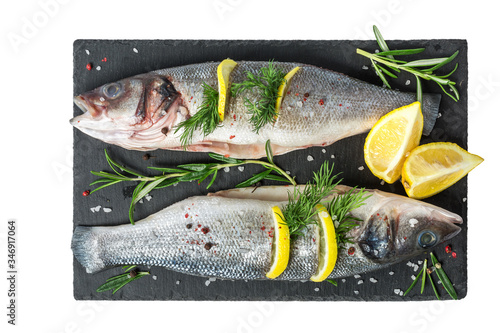 Foto Fresh fish seabass and ingredients for cooking on black slate isolated on white background