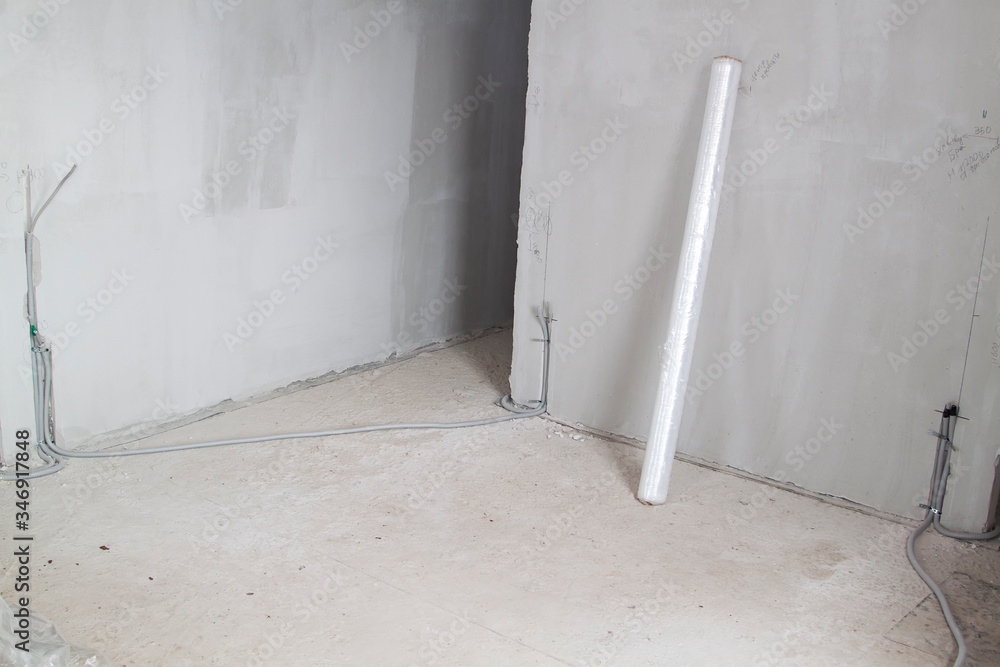 electrical cable is laid in protective corrugation in groove in wall. electrical wires are carried in wall to connect sockets and switches