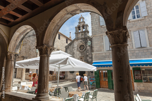 View through the arches of old house to lively square in medieval Korcula in Dalmatia, Croatia photo