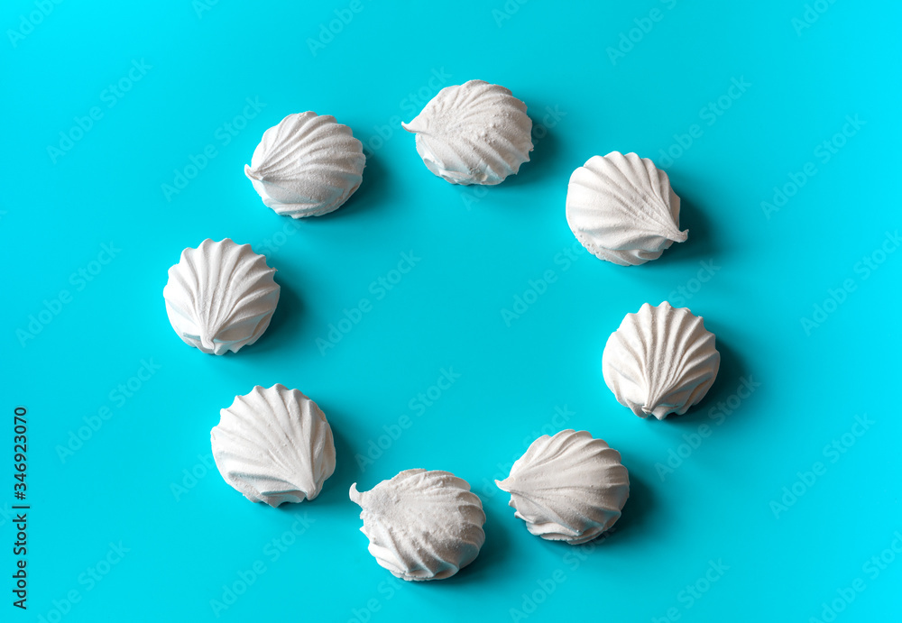 white vanilla marshmallows laid out in a circle on a blue background. magic circle made of white marshmallows. place for text. free space white vanilla marshmallows laid out in a circle on a blue background. magic circle made of white marshmallows. place for text. free space