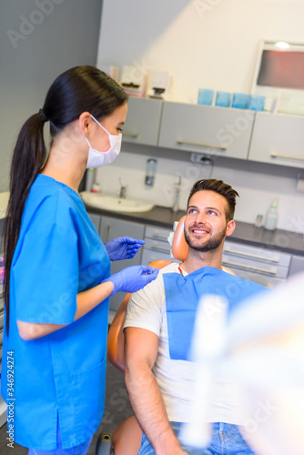 A female Dentist treating a patient in a dental practice
