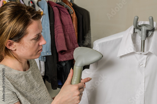 Woman ironing shirt with steam iron