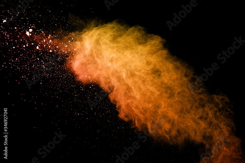 Launched orange powder on black background.