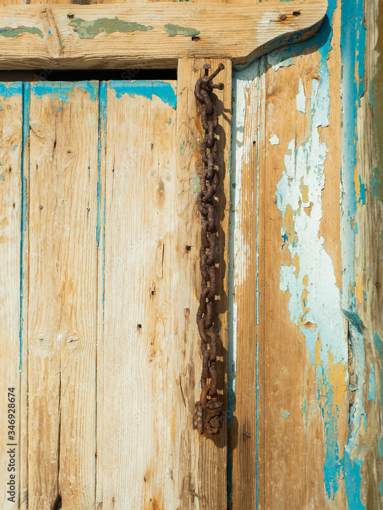 A Rust Chain and Cracked Paint at Klima Fishing Village - Milos Island, Greece