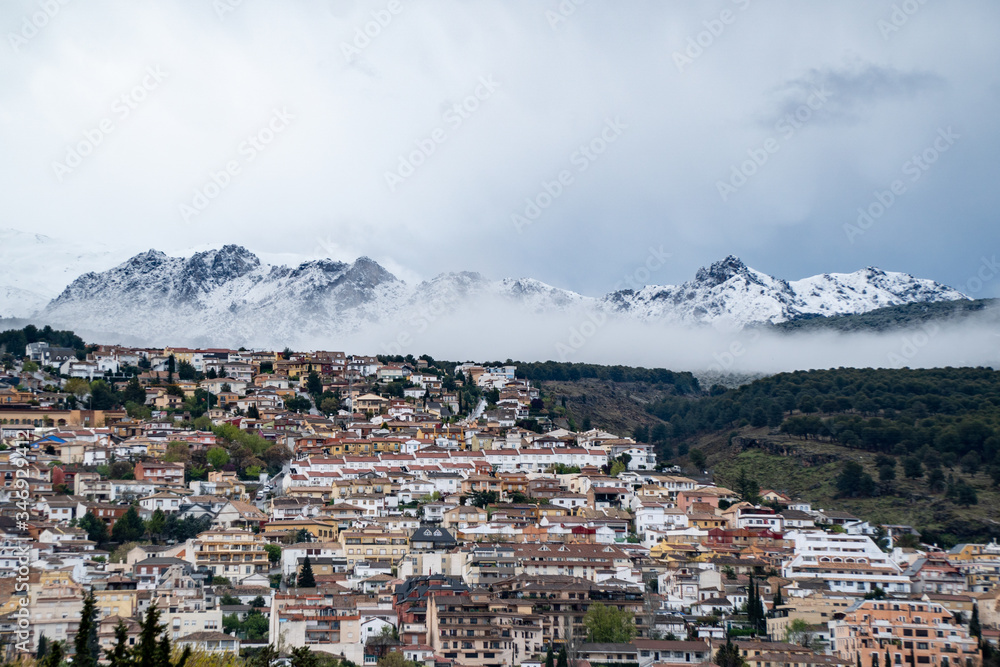 Beautiful Winter View Over a Snowy Mountain. Snow clouds over a city in the snowy mountains.