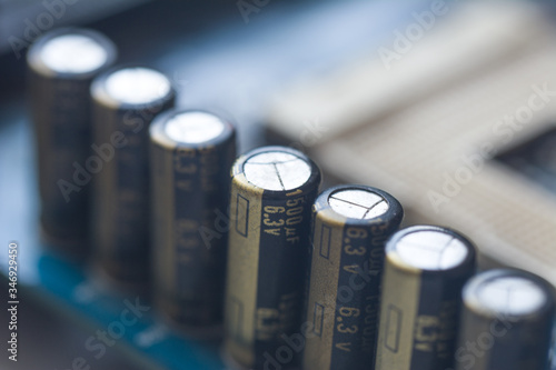 Fragment of the motherboard with electrolytic capacitors. Capacitive Assembly. Electronic component capacitor on the blue printed circuit board.