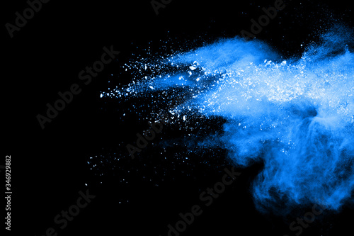 Blue dust explosion on black background. Freeze motion of color powder splash.