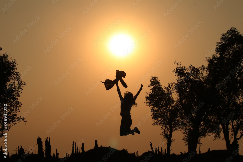 silhouette of a woman jumping in sunset silhouette of a woman jumping in sunset