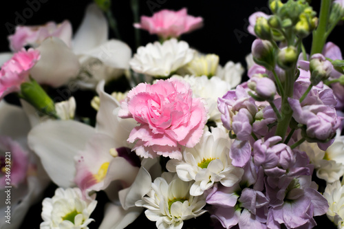 Spring bouquet of flowers in white and pink tones on a black background. Carnations. Flowers for mother's Day
