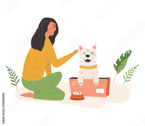 Young cute volunteer girl feeding street dog