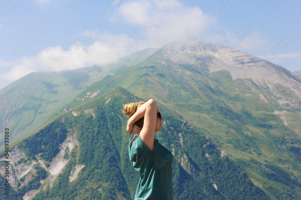 Naklejka premium Beautiful girl enjoys the fresh air in the mountains.