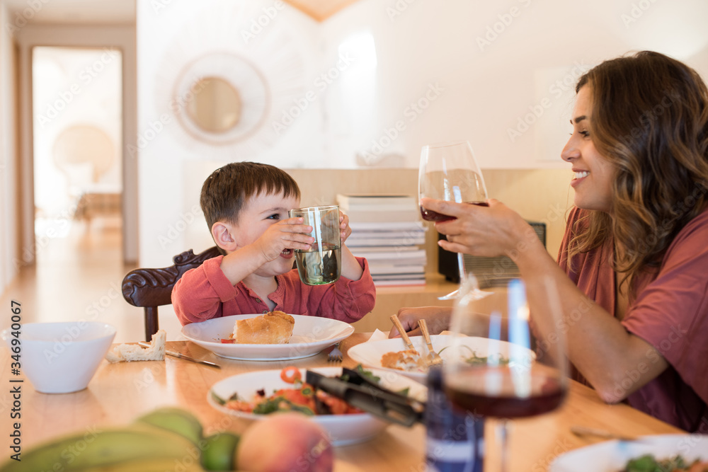 Young family with a little child sitting together for lunch Young family with a little child sitting together for lunch