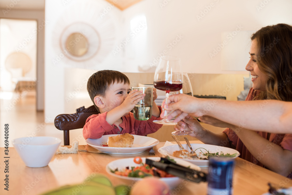 Young family with a little child sitting together for lunch Young family with a little child sitting together for lunch