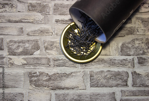 Black Nails on a metal stand against a brick wall.