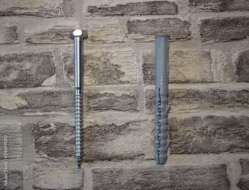Anchor plug with universal wrench screw against a brick wall.