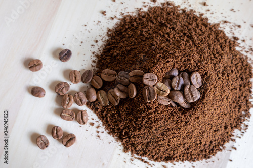 Top view of coffee beans and ground coffee on wooden background, roasted coffee volcano like anthill photo